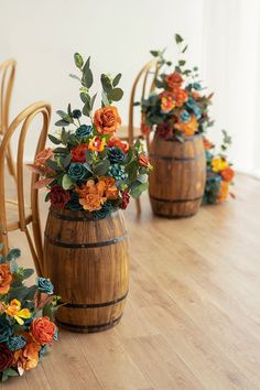 three wooden vases filled with flowers on top of a hard wood floor next to chairs