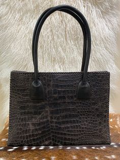 This lovely handbag features genuine antelope hair on hide on the front and croco embossed leather on the back. The straps and leather whipstitch details are done by hand. Strap length is perfect for over shoulder or carry. Due to lighting used during photography, actual finishes may vary from imagery. Exterior: Magnetic closure. Footed bottom. Interior: Leather lined. Center zip compartment, small zip pocket, cell phone pocket, credit card pockets and key fob holder. Dimensions: 16.5 x 12.5 x 4 Key Fob Holder, Hand Strap, Key Fob, Magnetic Closure, Embossed Leather, Zip Pockets, Cell Phone, Credit Card, Handbags