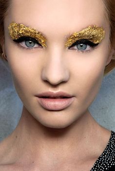 a woman with gold glitter on her eyes