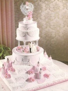 a three tiered wedding cake with bride and groom figurines on top