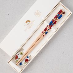 two chopsticks in a box with designs on them