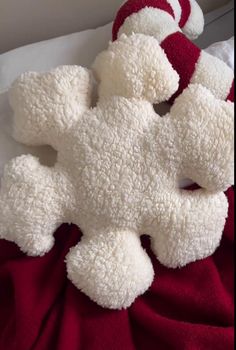 two white teddy bears laying on top of a red blanket