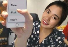 a woman holding up a cell phone with the words mute, block, and report on it