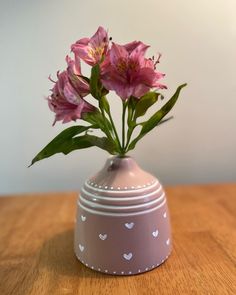 a vase with pink flowers in it sitting on a table