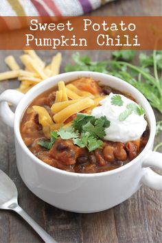 sweet potato pumpkin chili in a white bowl with sour cream on top