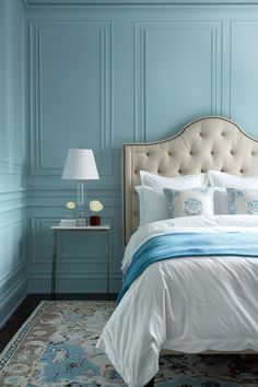 a bedroom with blue walls and white bedding