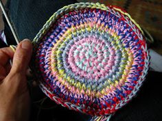 a person is holding a crocheted basket with yarn