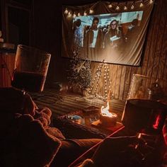 a living room filled with furniture and a projector screen in the middle of it