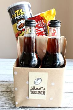 two bottles of soda and some snacks in a box on a table with an instagramr