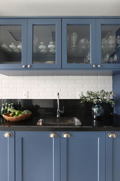 a kitchen with blue cabinets and black counter tops