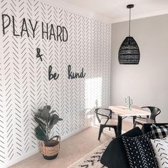 a black and white living room with play hard and be kind written on the wall