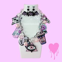 Step up your outfit's creepy cute factor with our one of a kind Pastel Goth statement necklace and earrings set! The intricate shapes and pearl details on the jewelry will make a stylish splash. Whether you pair it with a little black dress for a night out or a simple white tee for everyday wear, this necklace is guaranteed to be your new go-to accessory. Spooky season just got a whole lot cuter. **HAVE QUESTIONS?** ▶Checkout our FAQ Section or feel free to send us an Etsy Conversation! We try to return all messages within 24 hours. We process orders as entered so it it extremely important to check for accuracy prior to submitting the order. **CANCELATIONS** Request a cancellation within: 3 hours of purchase. No order cancellations after 24 hours of purchase. Visit our shop for more unique Edgy Halloween Jewelry For Costume Party, Edgy Pink Party Jewelry, Whimsical Halloween Dangle Jewelry, Pink Punk Halloween Jewelry, Pink Punk Necklace For Party, Handmade Edgy Halloween Jewelry, Pink Punk Style Necklace For Party, Handmade Edgy Jewelry For Halloween, Edgy Handmade Halloween Necklaces