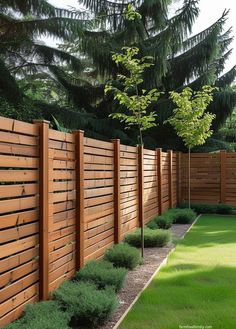 a wooden fence in the middle of a green yard