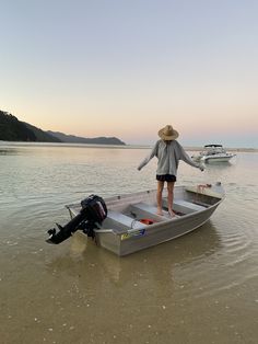 a woman standing on top of a boat in the water