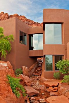 a house with rocks and water in front of it