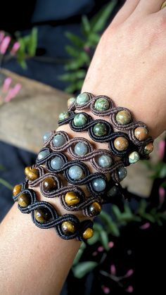 a close up of a person's hand wearing a bracelet with beads on it