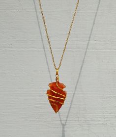 You are purchasing one handmade natural Carnelian crystal Arrowhead necklace pendant. These beautiful pendants are carefully cut, polished with care and have been personally chosen and selected under superior QC. We always prioritize the quality ahead and so as we use 100% genuine material in our Gemstones. ➤ Arrowhead Necklace size is Around 1 to 1.5 Inches What is Included? 1x Carnelian Spiral Arrowhead Necklace 1x Golden / Silver Chain for Women 1x Premium Adjustable Boho Cord for Men 1x Prem Amulet Style Necklace With Raw Stone For Gifts, Amulet Necklace With Raw Stone For Gifts, Amulet Necklace With Raw Stone As A Gift, Raw Stone Amulet Necklace As Gift, Gold Carnelian Crystal Necklace As Gift, Gold Carnelian Crystal Necklace Gift, Hand Wrapped Gold Agate Necklaces, Hand Wrapped Gold Agate Necklace, Gold Arrowhead Necklace As A Gift