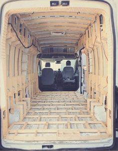 the back end of an empty van with wood planks on it's floor