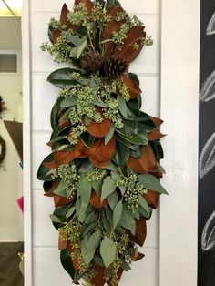 a wreath made out of leaves and pine cones