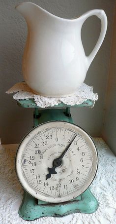 a white pitcher sitting on top of a scale