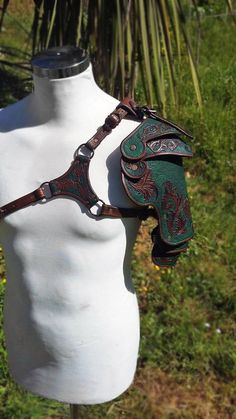 a white mannequin with a green and red leather harness on it's head