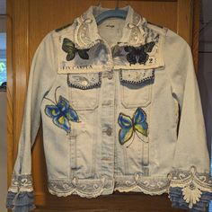 a denim jacket with butterfly appliques on it