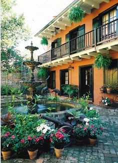 an outdoor courtyard with potted plants and water fountain