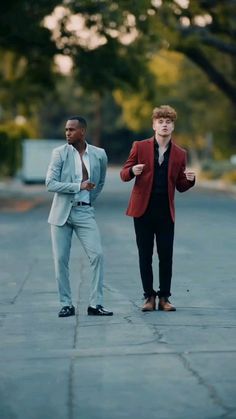 two men in suits standing on the street