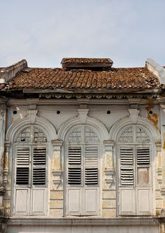 an old building with white shutters and windows