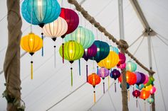 many colorful lanterns are hanging from the ceiling