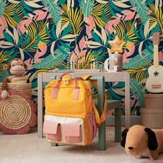 a room with colorful wallpaper and stuffed animals on the floor next to a small table