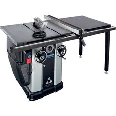 a table sawing machine sitting on top of a wooden table next to a metal object