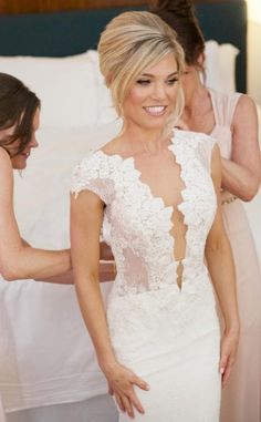 a woman in a white wedding dress standing next to another woman