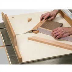 a person cutting wood on top of a piece of plywood with a large knife