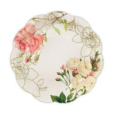 a white plate with pink flowers and green leaves on the rim, against a white background