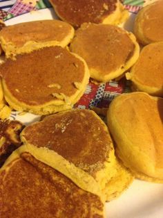 some pancakes are on a plate with butter and syrup in the middle one has been cut into small pieces