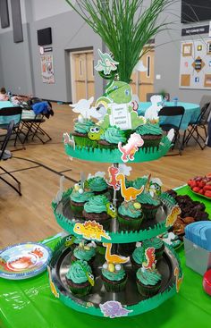 there are cupcakes on three tiered trays in the middle of a table