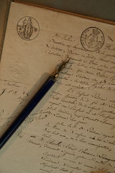 an old manuscript with writing on it and a fountain pen