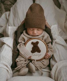 a baby is holding a brown teddy bear