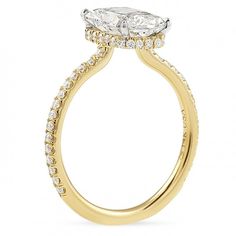 a yellow gold engagement ring with an oval shaped diamond center and side stones on the band