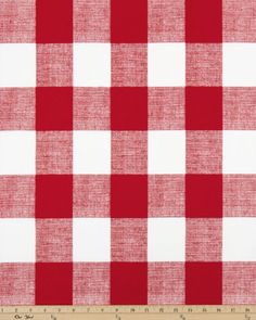 a red and white checkered tablecloth with a ruler in front of the fabric