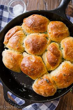 a skillet filled with bread rolls on top of a wooden table