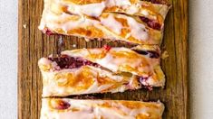 sliced up pastries sitting on top of a wooden cutting board