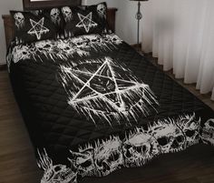 a bed covered in black and white sheets with skulls on the bottom, and a pentagram