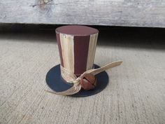 a small top hat with a wooden button on it's side sitting on the ground