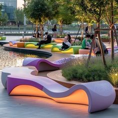 people are sitting on benches in the middle of an open area with water and trees