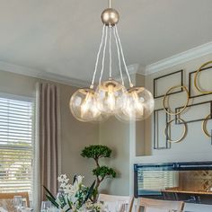 a dining room table with chairs and a chandelier hanging from it's ceiling