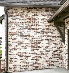 an old brick wall is painted white and brown