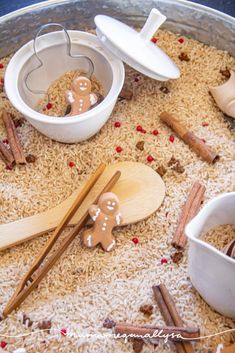 a pan filled with rice and wooden spoons next to other items on top of it