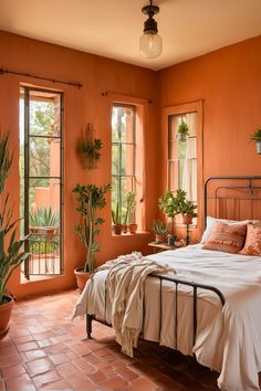 a bedroom with orange walls and flooring, plants on the window sill in front of the bed